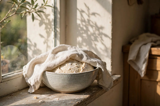 Dough rising under a cloth on a sunny windowsill