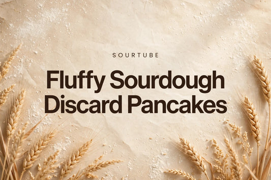 SourTube featured image: Fluffy Sourdough Discard Pancakes title on a warm flour-dusted bakery background